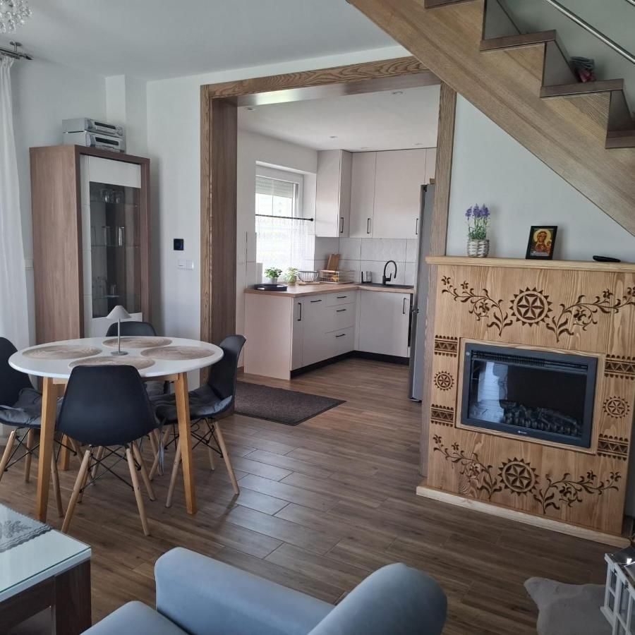 Salon z okrągłym stołem, kuchnią i jasnym piecem